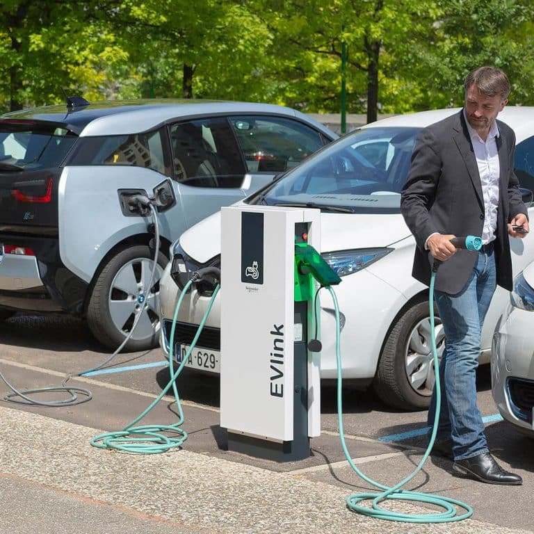 person plugging car using commercial EVLink charging station